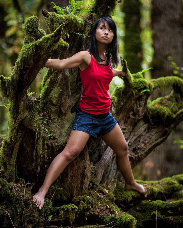 girl climbing on moss covered roots and stump