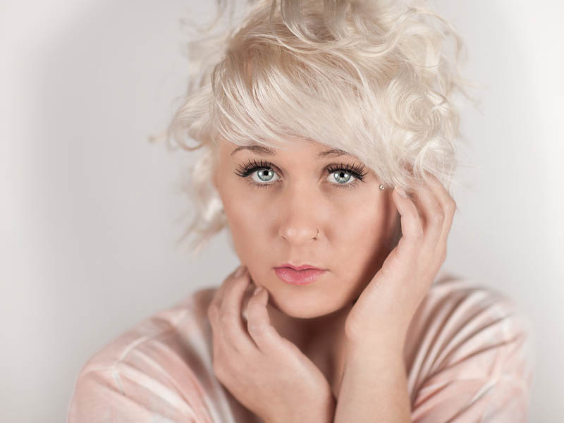 indoor portrait with blonde woman wearing pink top