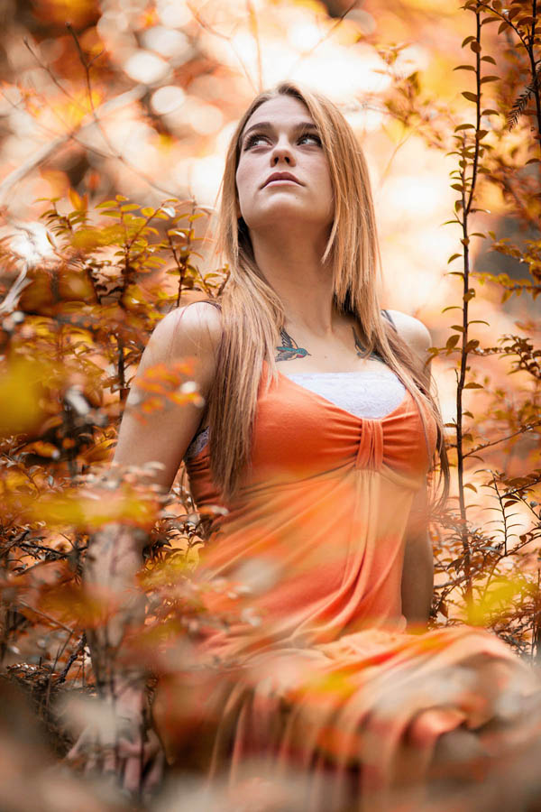 outdoor portrait young woman sitting in forest with bright sunlight