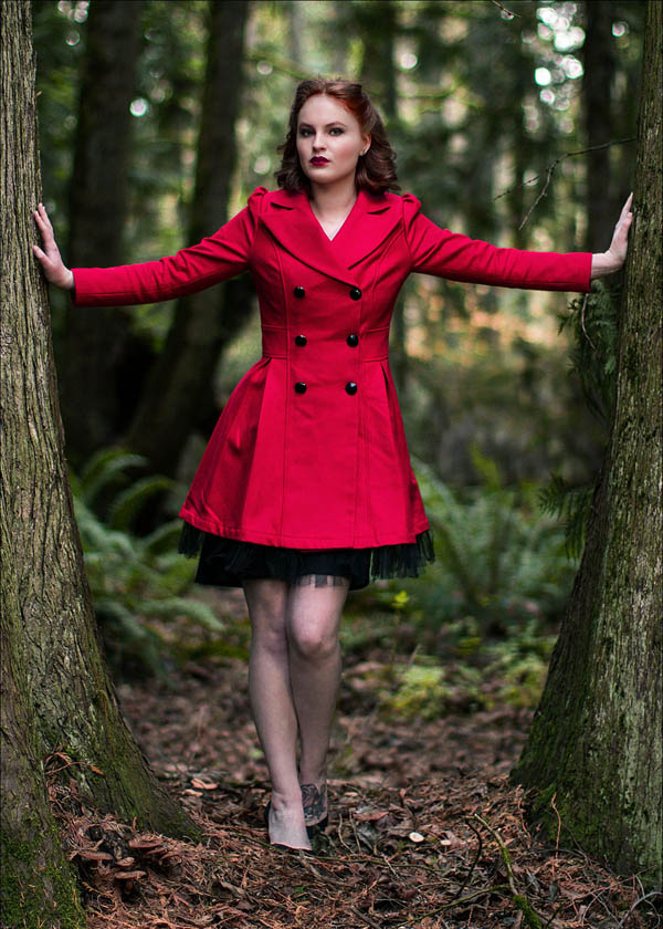 redhead woman wearing red coat next to cedar