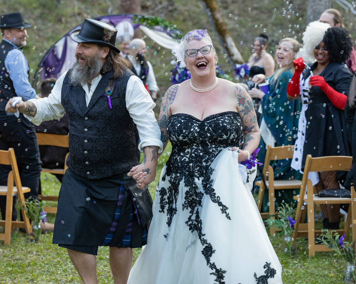 bride in white gown and strangers laughing